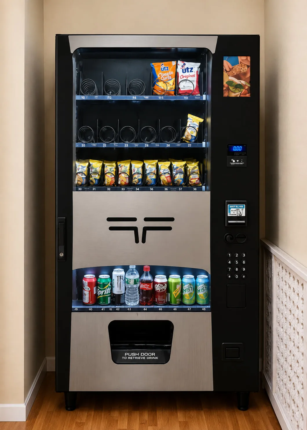 Combo vending machine holding snacks on the upper shelves and cold cans and bottles below, installed in a small office breakroom